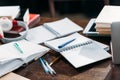 Open blank notebooks with pens and books on wooden table