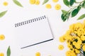 Open blank notepad among floral flat lay frame