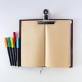 Open blank planner made from brown craft paper on white background with colorful brush pen. Travel notebook or sketchbook Royalty Free Stock Photo