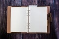 An open blank planner, spiral binders with leather cover and colorful tabs index.