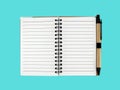 open blank small notebook with tan recycled paper ballpoint pen isolated on blue background Royalty Free Stock Photo