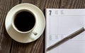 Open a blank white notebook, pen and cup of coffee on the wooden desk Royalty Free Stock Photo