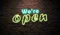 We `are Open Blue and green neon signboard style on dark brick background Royalty Free Stock Photo