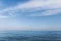 An open blue ocean with a blue sky with beautiful white clouds and a yacht far on the horizon. Traveling in Spain. Paradise.