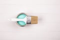 Open blue paint can and white brush on white wooden background. Royalty Free Stock Photo