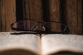 Open blurred page with hebrew religious text, glasses and old shabby leather-bound Jewish books Chumash on background Royalty Free Stock Photo