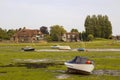 Open boats grounded at low tide in the historic harbour at Bosham in West Sussex in the South of England Royalty Free Stock Photo