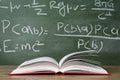 Open book against green chalkboard, close up Royalty Free Stock Photo