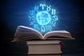 Open book on astrology on a dark background. The glowing magical globe with signs of the zodiac in the blue light Royalty Free Stock Photo