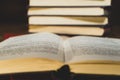 An open book on the background of a stack of books. Reading a book. close-up of an old book open on the library desk selective Royalty Free Stock Photo