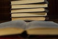 An open book on the background of a stack of books. Reading a book. close-up of an old book open on the library desk selective Royalty Free Stock Photo