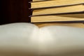 An open book on the background of a stack of books. Reading a book. close-up of an old book open on the library desk selective Royalty Free Stock Photo