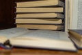 An open book on the background of a stack of books. Reading a book. close-up of an old book open on the library desk selective Royalty Free Stock Photo