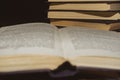 An open book on the background of a stack of books. Reading a book. close-up of an old book open on the library desk selective Royalty Free Stock Photo