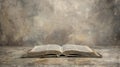 an open book Bible resting on a table against an abstract background, with empty space around it. The old, gray cover of Royalty Free Stock Photo