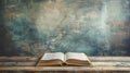 an open book Bible resting on a table against an abstract background, with empty space around it. The old, gray cover of Royalty Free Stock Photo