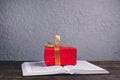 An open book of the Bible on the table. A gift on the Bible in a red box. A gift from God Royalty Free Stock Photo