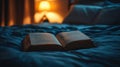 Open Book on Blue Bedding at Night Royalty Free Stock Photo