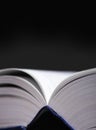 Open book with blue cover and black background Royalty Free Stock Photo