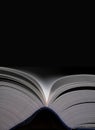 Open book with blue cover and black background Royalty Free Stock Photo