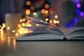 Book and blurred Christmas tree on background Royalty Free Stock Photo