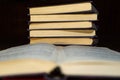 An open book with blurred text on the background of a stack of books Royalty Free Stock Photo
