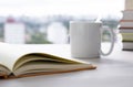 Open book, coffee cup and pile of books over wood table with cityscape cloudy background Royalty Free Stock Photo