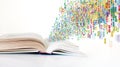 Open book with colorful digital icons flowing from the pages, symbolizing information technology Royalty Free Stock Photo