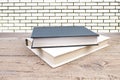 open book. Composition with hardback books, fanned pages on wooden deck table and Brick wall background. Books stacking. Back to Royalty Free Stock Photo