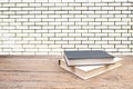 open book. Composition with hardback books, fanned pages on wooden deck table and Brick wall background. Books stacking. Back to Royalty Free Stock Photo