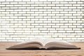 open book. Composition with hardback books, fanned pages on wooden deck table and Brick wall background. Books stacking. Back to Royalty Free Stock Photo