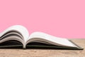 open book. Composition with hardback books, fanned pages on wooden deck table and pink background. Books stacking. Back to school Royalty Free Stock Photo