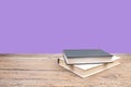 open book. Composition with hardback books, fanned pages on wooden deck table and purple background. Books stacking. Back to Royalty Free Stock Photo