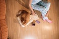 Open book, cup of tea, smartphone and red cat on wooden floor near to woman. Top view. Cozy home concept Royalty Free Stock Photo