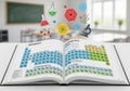 An open book displays the periodic table of elements, including categories like nonmetals, transitio Royalty Free Stock Photo