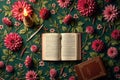 Open book on floral background with candle and red dahlias on green surface Royalty Free Stock Photo