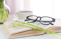 Open book , fresh lilies of the valley and a cup of morning coffee on the table. Close-up. Selective focus Royalty Free Stock Photo