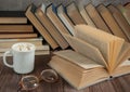 An open book, glasses, a cup of cocoa with a marshmallow close - up on a wooden background. Royalty Free Stock Photo