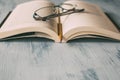 Open book with glasses and pencil on wooden table as background. Education, wisdom and study concept. Royalty Free Stock Photo