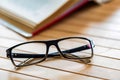 Open book and glasses on wooden table close Royalty Free Stock Photo