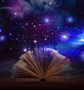 Open book with glitter overlay and beautiful universe on background