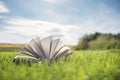 Open book on green grass in a field background Royalty Free Stock Photo