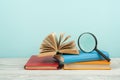 Open book, hardback colorful books on wooden table. Magnifier. Back to school. Copy space for text. Education business concept Royalty Free Stock Photo