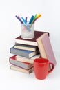 Open book, hardback colorful books on wooden table, white background. Back to school. Pens, pencils, cup. Copy space for Royalty Free Stock Photo