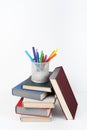 Open book, hardback colorful books on wooden table, white background. Back to school. Pens, pencils, cup. Copy space for Royalty Free Stock Photo