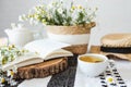 Open book, herbal chamomile tea cup on wooden table, reading and morning relax concept Royalty Free Stock Photo