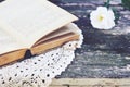 Open book on lace doily on rusted garden table