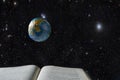 An open book, a levitating model of the planet earth levitates above it, against the background of outer space with stars. The Royalty Free Stock Photo