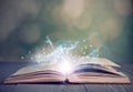 Open book with magic glowing on table. Fairy tale Royalty Free Stock Photo