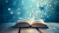 Open book with magic light and glowing butterflies flying out of it on wooden table against light blue bokeh background Royalty Free Stock Photo